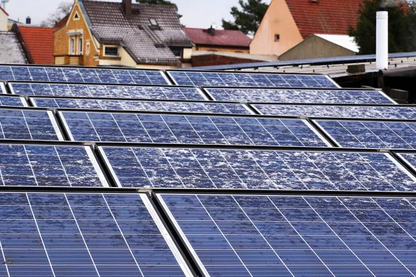 Alternatif elektrik kaynağı. Çatıdaki evde karla kaplı fotovoltaik güneş panelleri. Yenilenebilir enerji üretimi. Kaynaklar ekolojik enerji santrali.