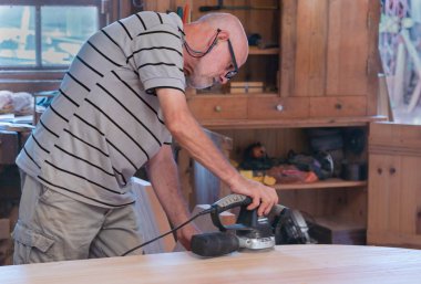Male carpenter, working in the carpenter's workshop with power h