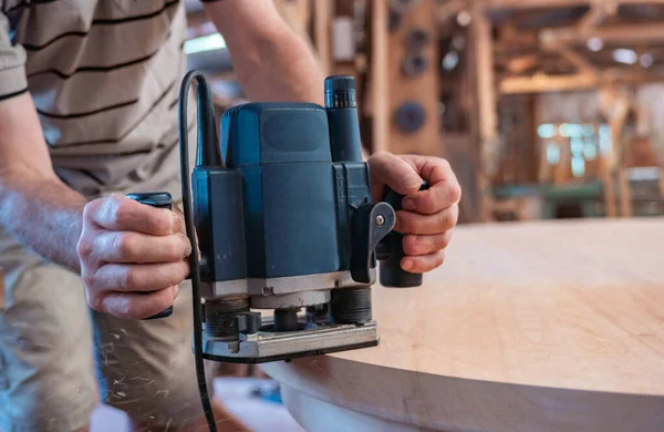 Male carpenter, working in the carpenter's workshop with power h