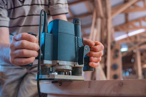 Male carpenter, working in the carpenter's workshop with power h