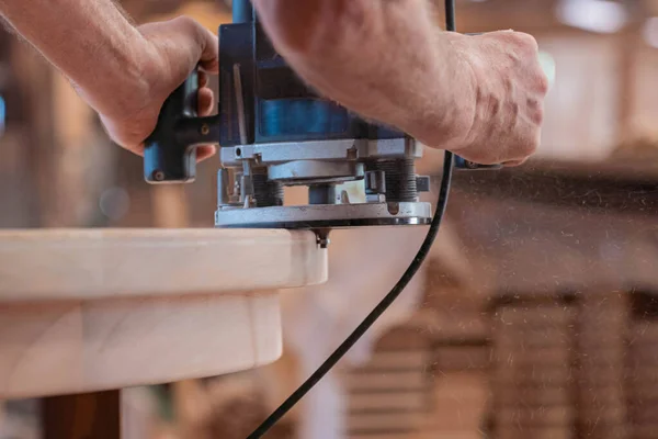Male carpenter, working in the carpenter's workshop with power h