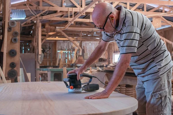 Male carpenter, working in the carpenter's workshop with power h