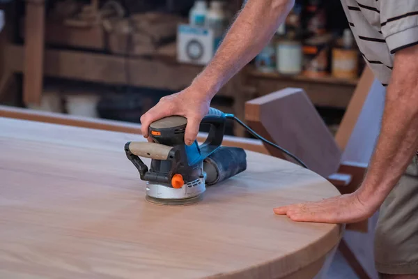 Male carpenter, working in the carpenter's workshop with power h