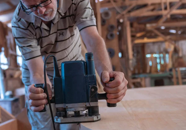 Male carpenter, working in the carpenter's workshop with power h