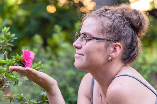 Mutlu kız doğal bir çiçeğe yakından bakıyor. Baharı takdir ediyorum.