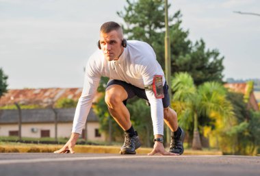 Healthy lifestyle fitness athletes running. Athlete using smartphone and viewing times on watch. 