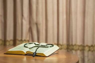 Holy Week religious composition with wooden crucifixion, palm leaf, willow branch, wheat ear. Bible and rosary. Holy week concept, Sunday in copy space.