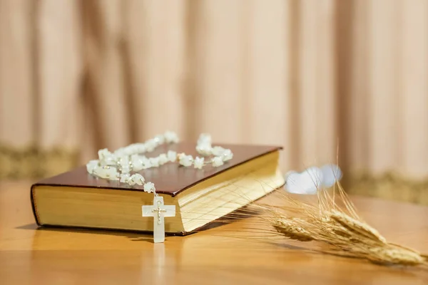 Holy Week religious composition with wooden crucifixion, palm leaf, willow branch, wheat ear. Bible and rosary. Holy week concept, Sunday in copy space.