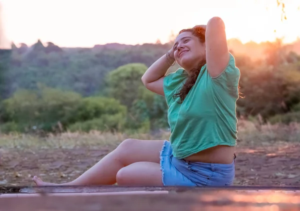 young girl with sun in background talking cheerfully on cell phone