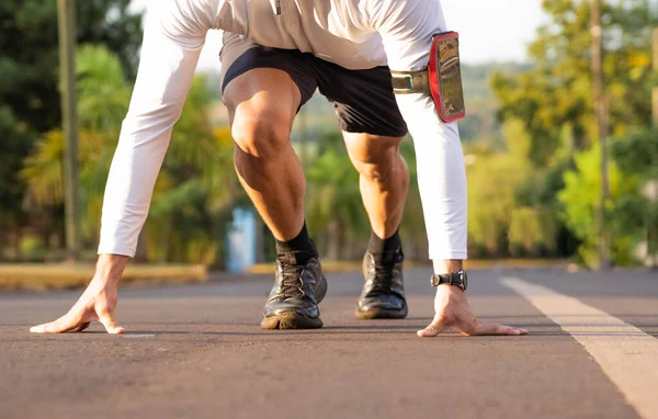 Young male person training, monitoring times with smartphone.