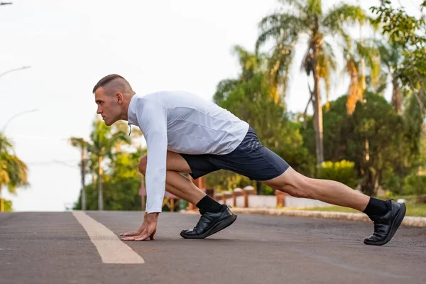Young male person training, monitoring times with smartphone.