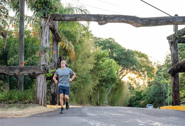 Young male person training, monitoring times with smartphone.
