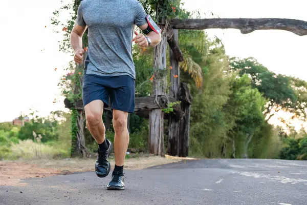 Young male person training, monitoring times with smartphone.