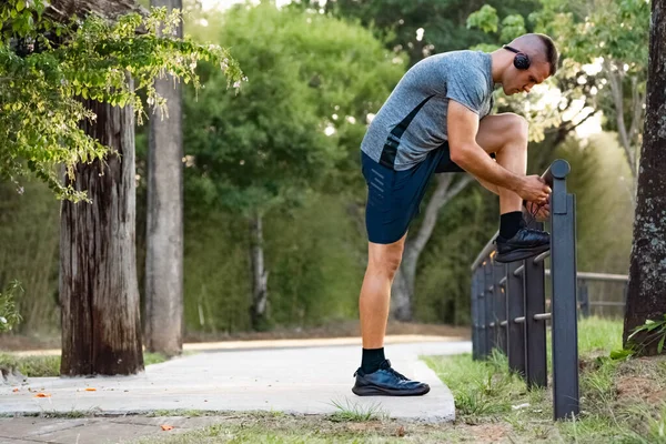 Young male person training, monitoring times with smartphone.