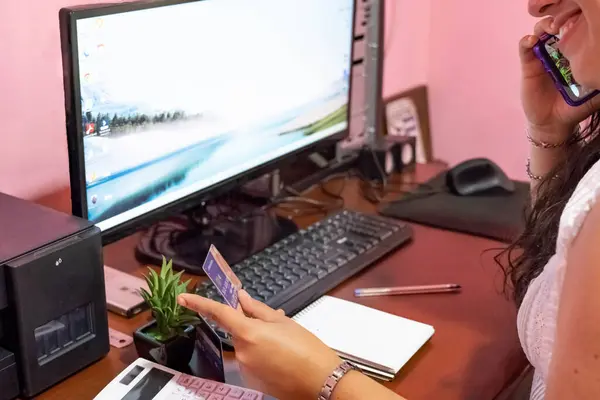 secretary making online purchases with a credit card in the office