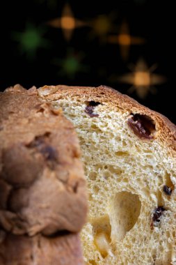 Pastanın içindeki yılbaşı ışıklarının arka planında panettone 'un yakın plan görüntüsü.