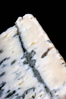 Damarları ve kalıpları gösteren bir dilim Rokfor peynirinin yakın çekimi.