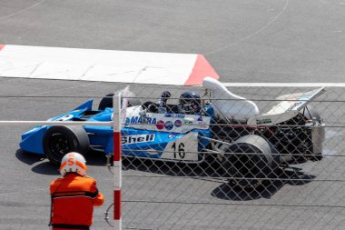 12 Mayıs 2024 'teki Monaco Tarihi Grand Prix sırasında yarış hosteslerinin yazı tipinden geçen klasik yarış arabası.