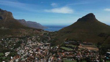 Aerial footage of Cape Town with Lions Head, ocean and Table Mountain on background 