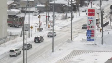 Hokkaido, Japan - January 24, 2023: A diesel-powered vehicle for Nemuro station passing rail crossing in snow.