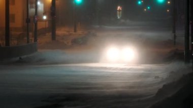 Hokkaido, Japan - January 24, 2023: A car running under heavy snow and strong wind at midnight in Nemuro, Hokkaido, Japan 