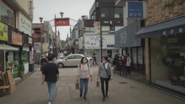 Kanagawa, Japonya - 26 Mayıs 2023: Japonya 'nın Kamakura kentindeki meşgul Komachi dori caddesinde yürüyen turistler