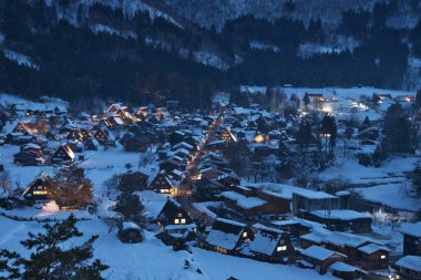 Gifu, Japonya - 19 Ocak 2025: Shirakawago, Gifu, Japonya 'da aydınlatılmış sazdan çatı evleri panoramik görünümü