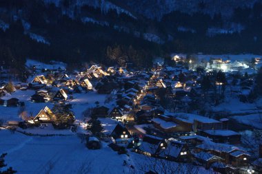 Gifu, Japonya - 19 Ocak 2025: Shirakawago, Gifu, Japonya 'da aydınlatılmış sazdan çatı evleri panoramik görünümü