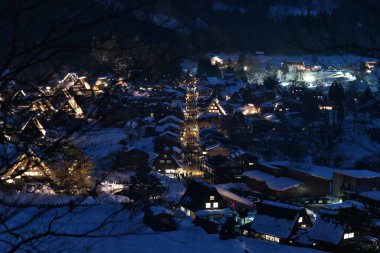 Gifu, Japonya - 19 Ocak 2025: Shirakawago, Gifu, Japonya 'da aydınlatılmış sazdan çatı evleri panoramik görünümü
