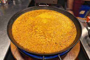 Barselona, İspanya - 17 Mart 2025: Büyük paelia tavasında İspanyol paelia pişirme