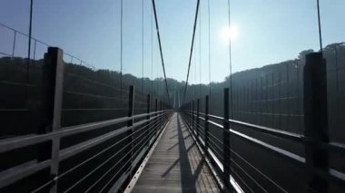 Shimane, Japonya - 28 Haziran 2025: Shimane, Japonya 'da Sunrise' da Oni-no-shitaburui 'de Oomaki Nehri üzerinde uzun bir asma köprü