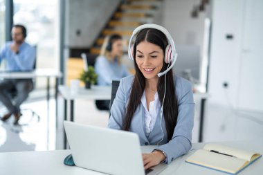 Call center worker having conversation with customer during online chat support at office