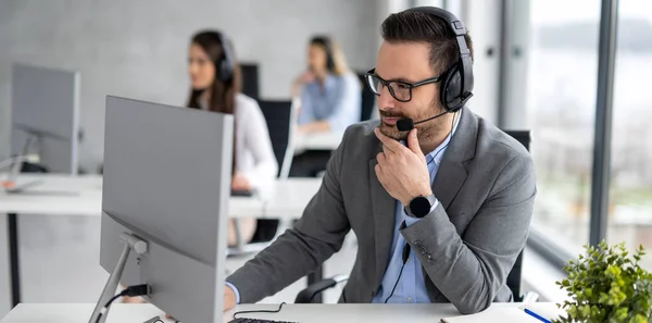 Handsome male customer support executive agent working at call centre