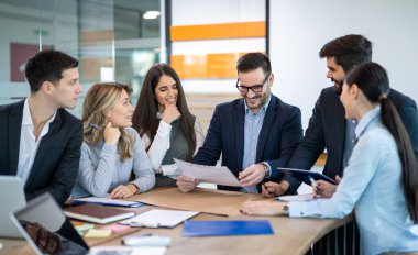Şirket yöneticilerinden oluşan bir ekip şirkette yıllık mali rapor dengesini analiz ediyor. İyi sonuçlar, iş, pazar, ofis ve vergi kavramı.