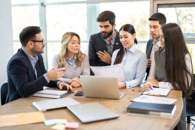 Corporate business group discussing paperwork on a meeting in office clipart