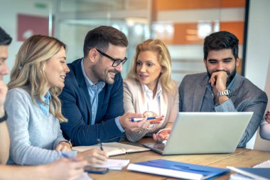 Bir grup profesyonel proje yöneticisi toplantı odasında müzakere ediyor..