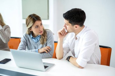 Ciddi kadın ve erkek yeni online iş trendlerini tartışıyor. İş kadını, projeyi dikkatle dinleyen erkek arkadaşına anlatıyor.