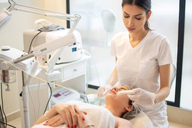 Genç bir kadın güzellik salonunda hidrakiyal terapi görüyor.