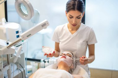 Güzellik uzmanı spa 'da kadın yüzüne enzimsel soyma uyguluyor..