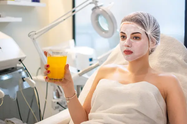 Beautiful Woman Having Facial Treatment Drinking Orange Juice Beauty Salon — Stock Photo, Image