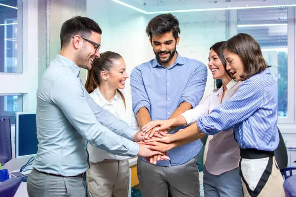 Group of diversity employees stacking hands together making strong team.