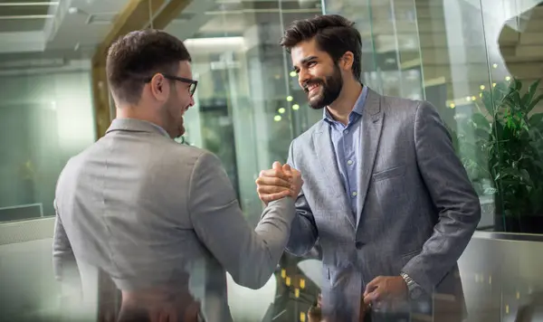 在现代玻璃办公室里 穿着正装 手牵手握手的成功商人们聚集在一起 成为庆祝成功的拳头 — 图库照片