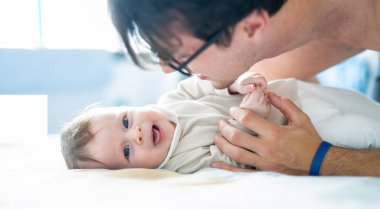 Mutlu baba yatak odasında küçük oğluyla oynuyor. Yakın çekim..