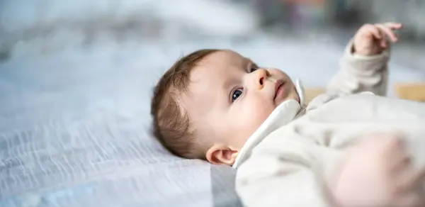 Sırtüstü uzanan ve yatakta dinlenen sevimli bir çocuğun yakın plan portresi. Boşluğu kopyala