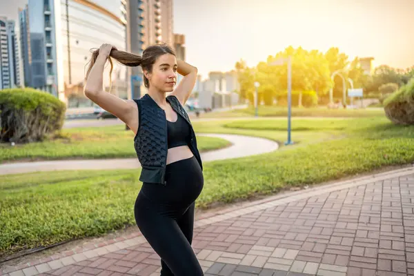 Portret Młodej Kobiety Ciąży Wiążącej Włosy Podczas Relaksującego Spaceru Parku — Zdjęcie stockowe