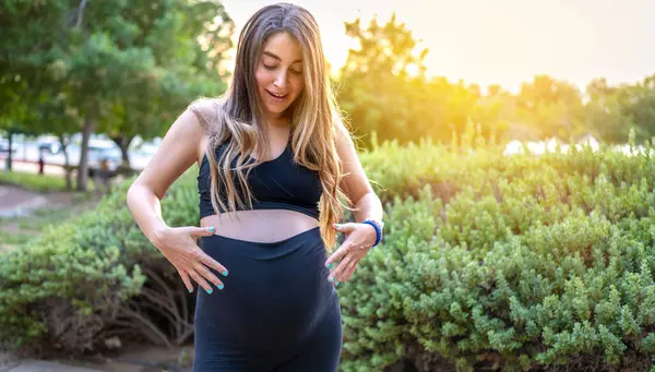 Excited Future Mother Looking Her Belly Arms While Standing Park — Stock Photo, Image