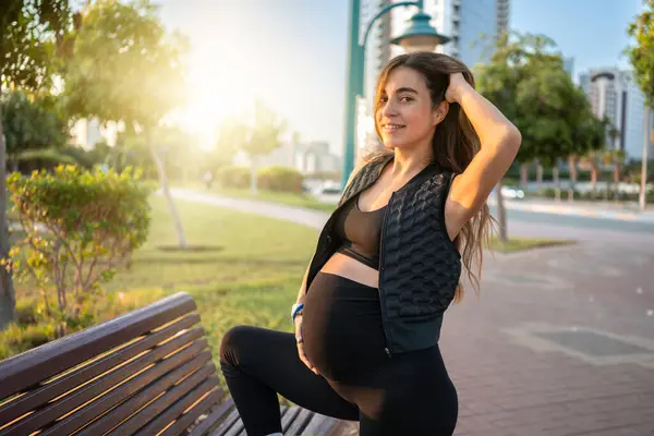 Gün Batımında Parkta Bacağıyla Poz Veren Güzel Hamile Bir Kadın — Stok fotoğraf