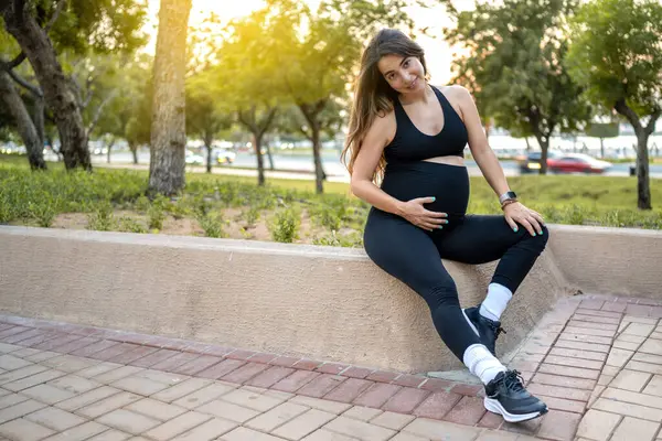 Schöne Schwangere Frau Sitzt Auf Steinmauer Und Entspannt Sich Park — Stockfoto