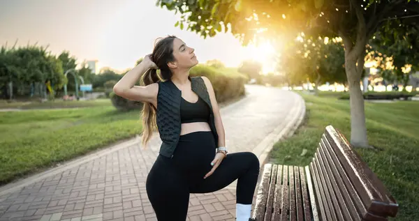 Spor Giyimli Hamile Bir Kadın Gün Batımında Parkta Hamileliğinin Tadını — Stok fotoğraf
