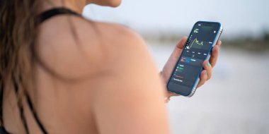 Diyabet kontrolünü geliştirmek için sürekli glikoz monitörü kullanan bir kadının omuz üstü görüntüsü. Akıllı telefon uygulamasında kan şekeri testi gösteren telefonu gösteren tanınmayan bir bayan..